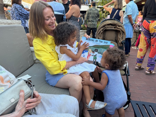 Little hands reaching for the book at a reading event