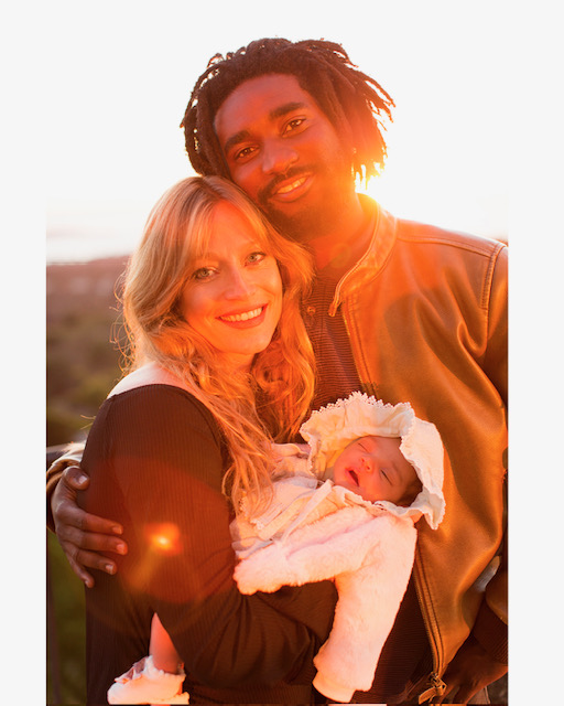 Eva and her husband with their newborn at sunset